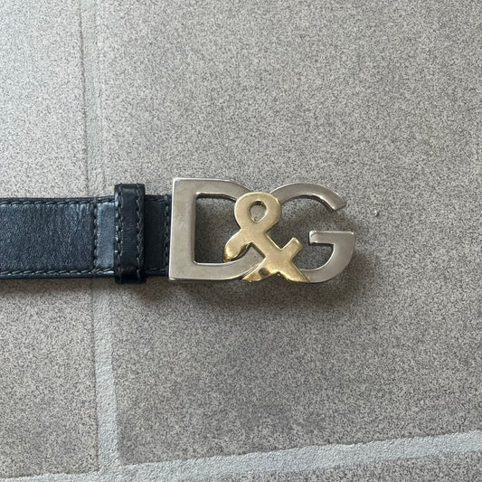 Dolce &amp; Gabbana Kids Logo Black Leather Belt features a black leather strap with a cutout DG logo buckle. The buckle combines a silver-tone “DG” design with a gold-tone ampersand detail. Made in Italy, the belt is crafted from 100% leather.