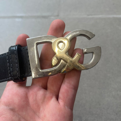 Dolce &amp; Gabbana Kids Logo Black Leather Belt features a black leather strap with a cutout DG logo buckle. The buckle combines a silver-tone “DG” design with a gold-tone ampersand detail. Made in Italy, the belt is crafted from 100% leather.