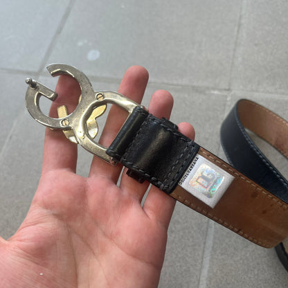 Dolce &amp; Gabbana Kids Logo Black Leather Belt features a black leather strap with a cutout DG logo buckle. The buckle combines a silver-tone “DG” design with a gold-tone ampersand detail. Made in Italy, the belt is crafted from 100% leather.