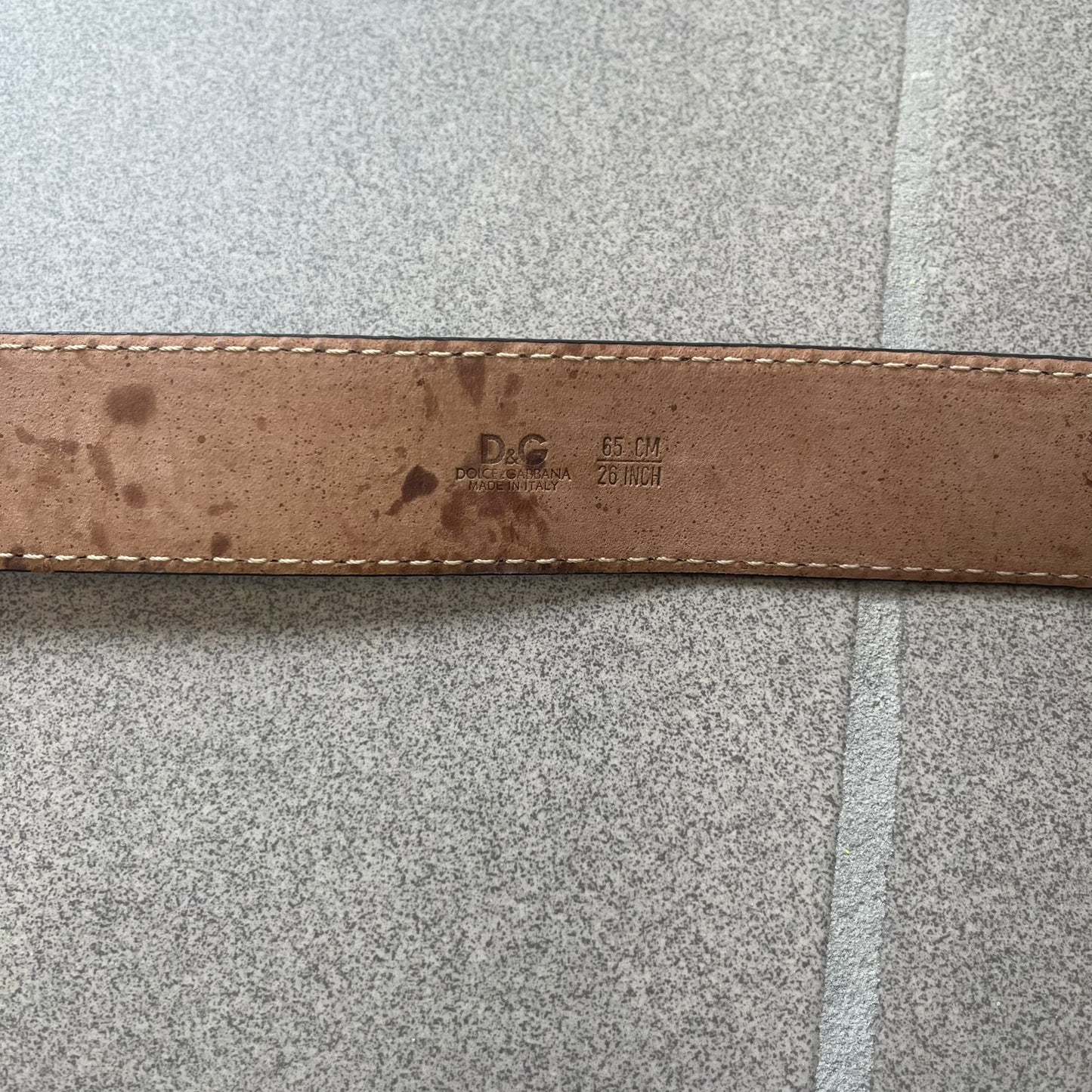 Dolce &amp; Gabbana Kids Logo Black Leather Belt features a black leather strap with a cutout DG logo buckle. The buckle combines a silver-tone “DG” design with a gold-tone ampersand detail. Made in Italy, the belt is crafted from 100% leather.