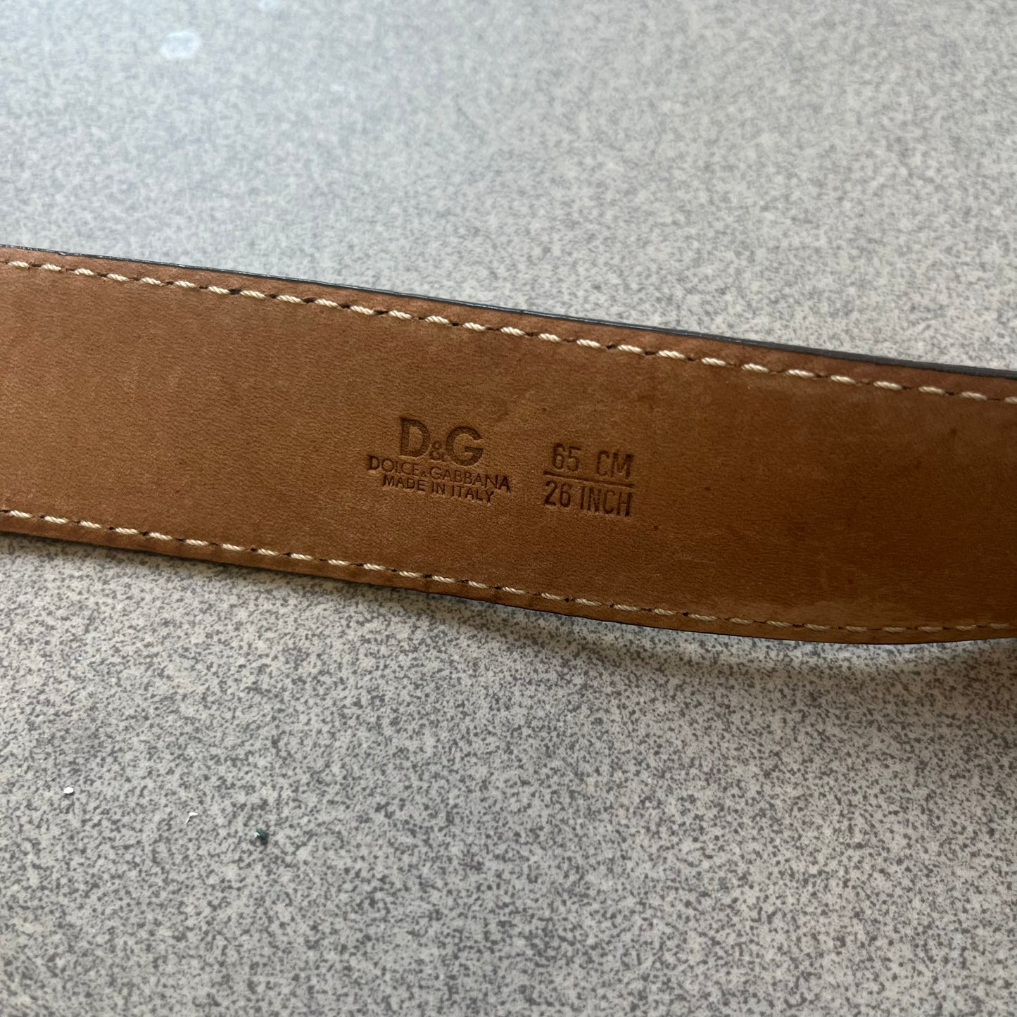 Dolce & Gabbana Kids Logo Brown Leather Belt features a brown leather strap with a cutout D&G logo buckle. The buckle combines a silver-tone “DG” design with a gold-tone ampersand detail. Made in Italy, the belt is crafted from 100% leather.
