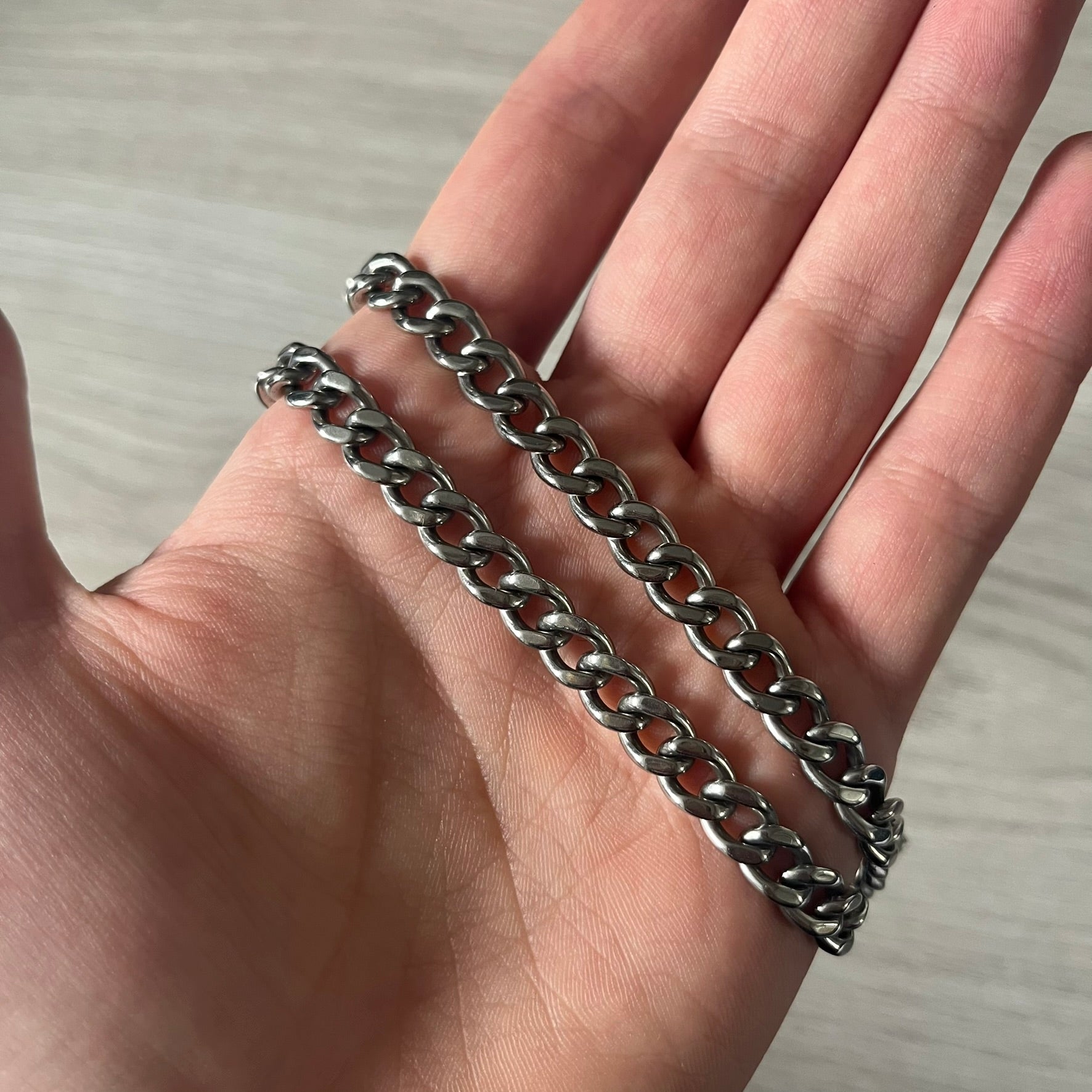 D&amp;G DJ0564 Pendant Necklace showcases a large silver curb chain paired with a rectangular silver frame pendant. Inside, black leather embossed with the D&amp;G logo adds contrast and sophistication. A striking blend of luxury leather and stainless steel craftsmanship.