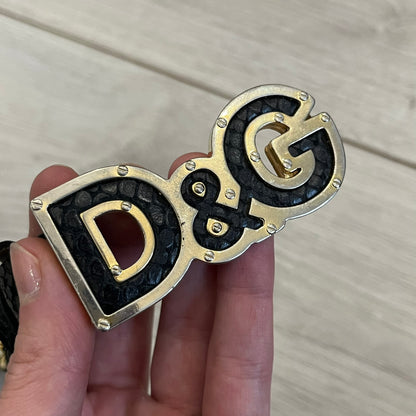 Dolce &amp; Gabbana Leather Studded Belt in black textured leather with a scaled, snake-like finish. The belt features gold stud detailing arranged in a clean pattern and a matching black D&amp;G buckle trimmed with gold hardware and exposed screws. The interior is finished in gold, adding a refined contrast to the overall design.