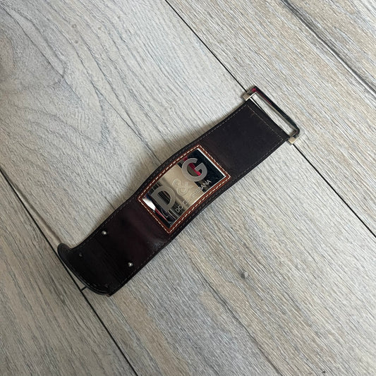Dolce & Gabbana Logo Leather Bracelet is a leather bracelet made in Italy. It features an adjustable closure and a large stainless steel plaque on the front. The plaque is engraved with the D&G logo and Dolce & Gabbana text. Silver-tone hardware is used throughout the bracelet.