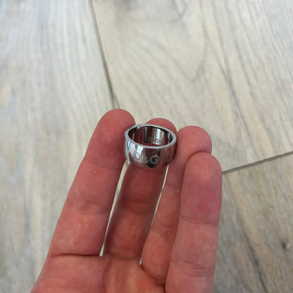 Dolce & Gabbana Logo Repeat Ring is a stainless steel ring featuring repeating engraved D&G logos around the entire band. The design is minimal and clean, focusing on subtle branded detailing and polished metal construction.