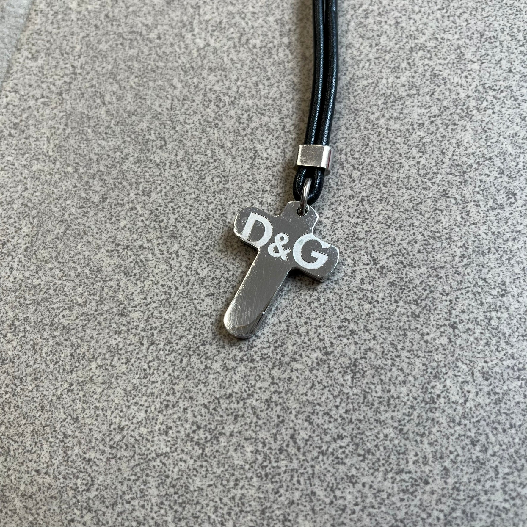 Dolce &amp; Gabbana Pearl Red/Black Rosary Necklace from the 2000's era. The necklace features a silver-tone metal cross with a D&amp;G logo, connected via a black leather link to a metal chain with alternating red and black pearl-style beads. Rosary-style construction with mixed materials including metal, leather, and resin pearls.&nbsp;