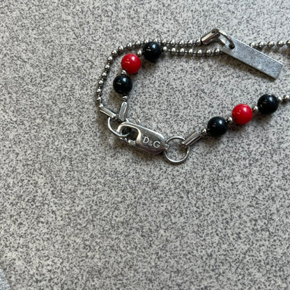 Dolce &amp; Gabbana Pearl Red/Black Rosary Necklace from the 2000's era. The necklace features a silver-tone metal cross with a D&amp;G logo, connected via a black leather link to a metal chain with alternating red and black pearl-style beads. Rosary-style construction with mixed materials including metal, leather, and resin pearls.&nbsp;