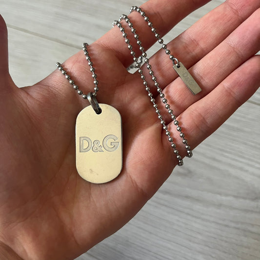 Dolce &amp; Gabbana plain logo dog tag necklace in silver-tone stainless steel, featuring the iconic D&amp;G logo engraved on a sleek tag. Suspended on a classic ball chain with a regulated size. A versatile accessory that combines minimal branding with everyday wearability.
