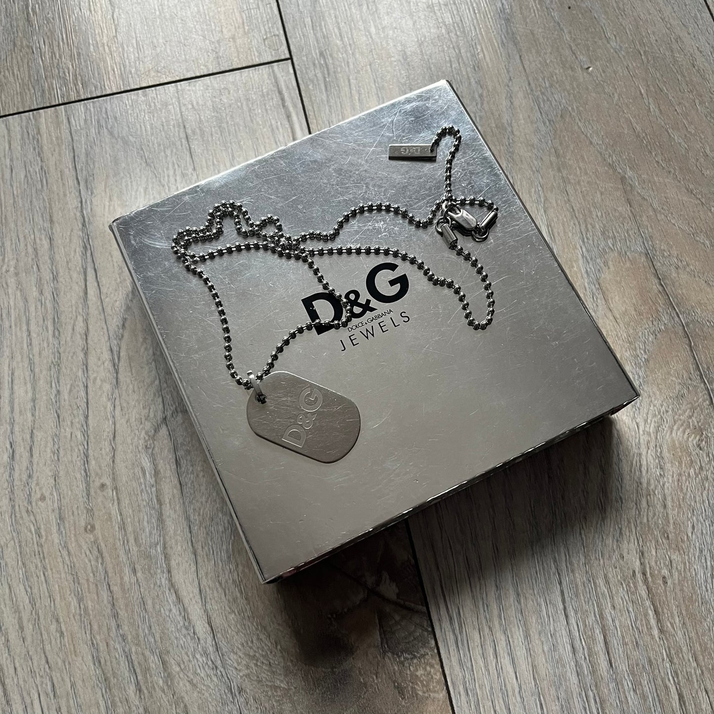 Dolce &amp; Gabbana plain logo dog tag necklace in silver-tone stainless steel, featuring the iconic D&amp;G logo engraved on a sleek tag. Suspended on a classic ball chain with a regulated size. A versatile accessory that combines minimal branding with everyday wearability.