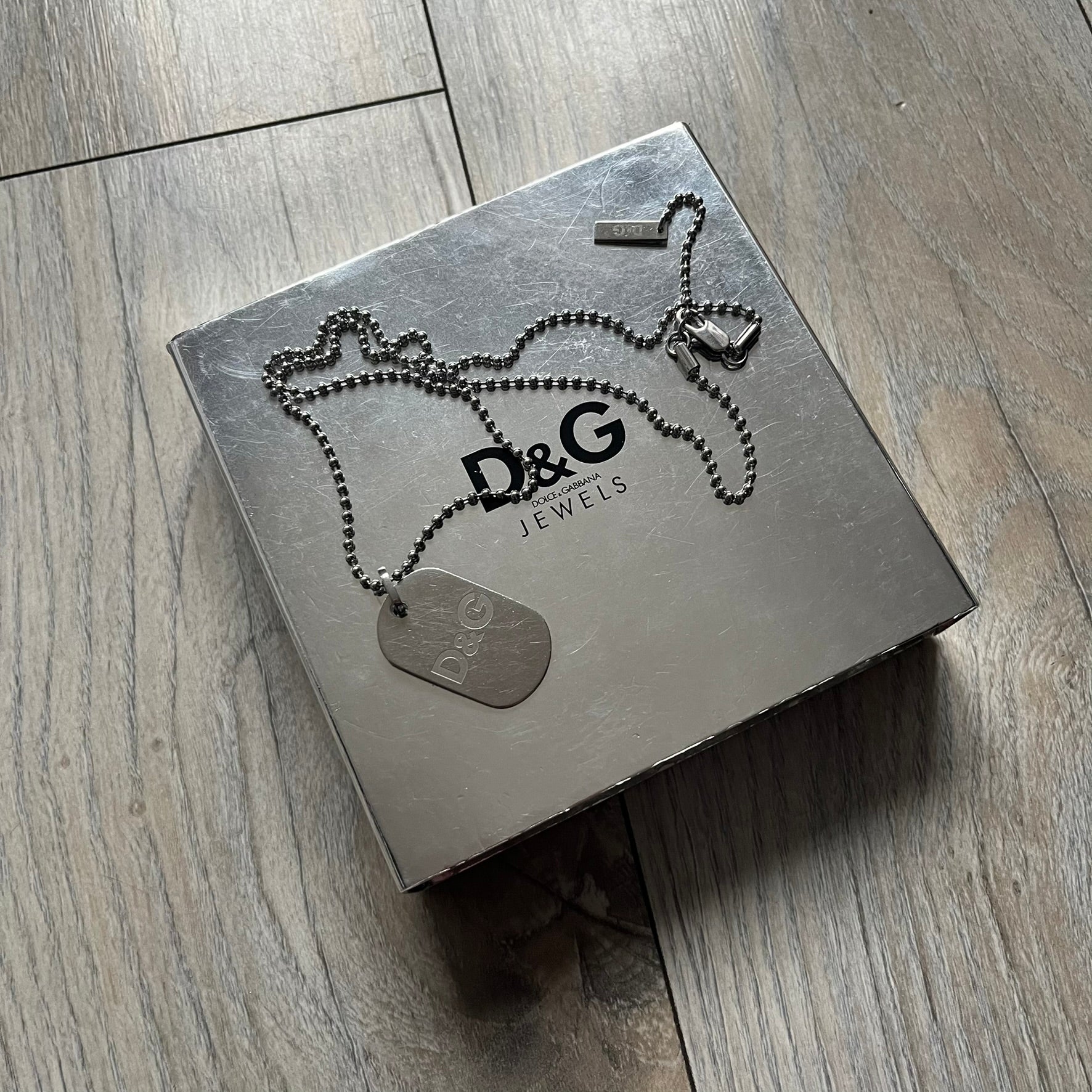 Dolce &amp; Gabbana plain logo dog tag necklace in silver-tone stainless steel, featuring the iconic D&amp;G logo engraved on a sleek tag. Suspended on a classic ball chain with a regulated size. A versatile accessory that combines minimal branding with everyday wearability.