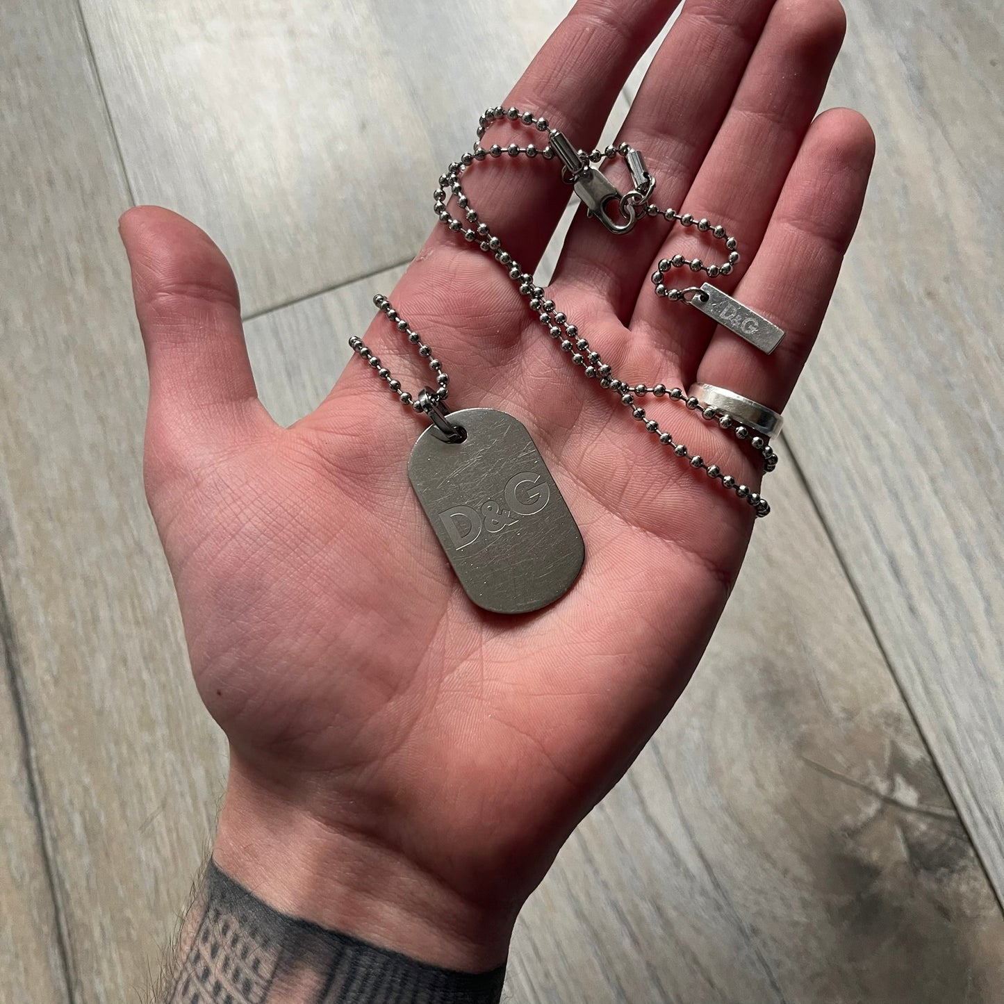 Dolce &amp; Gabbana plain logo dog tag necklace in silver-tone stainless steel, featuring the iconic D&amp;G logo engraved on a sleek tag. Suspended on a classic ball chain with a regulated size. A versatile accessory that combines minimal branding with everyday wearability.