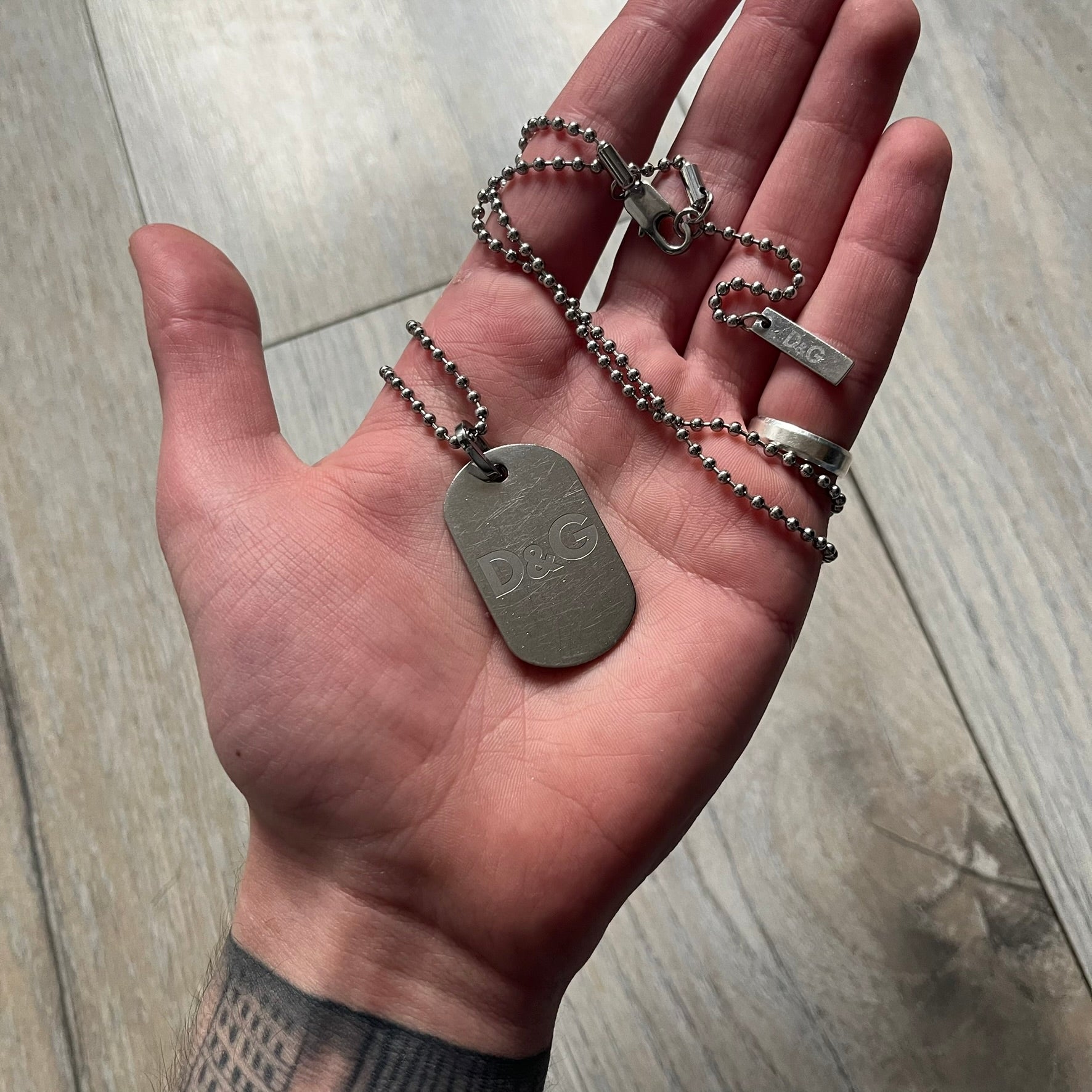 Dolce &amp; Gabbana plain logo dog tag necklace in silver-tone stainless steel, featuring the iconic D&amp;G logo engraved on a sleek tag. Suspended on a classic ball chain with a regulated size. A versatile accessory that combines minimal branding with everyday wearability.