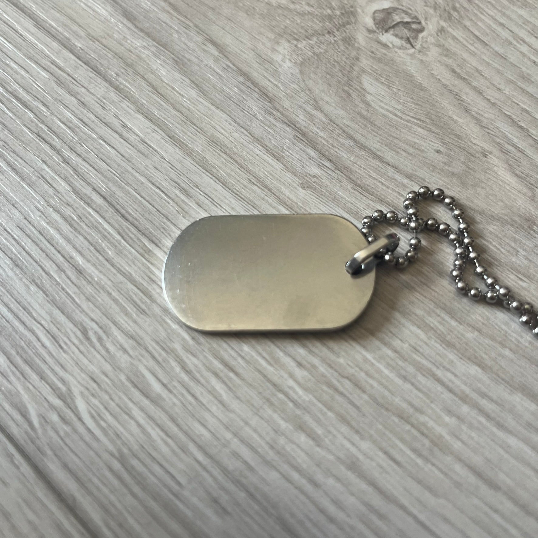 Dolce & Gabbana plain logo dog tag necklace in silver-tone stainless steel, featuring the iconic D&G logo engraved on a sleek tag. Suspended on a classic ball chain with a regulated size. A versatile accessory that combines minimal branding with everyday wearability.