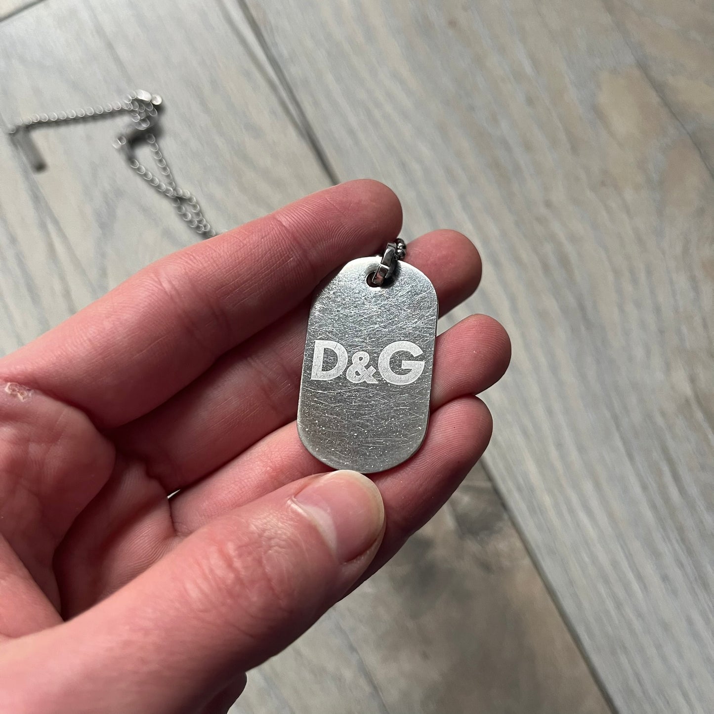 Dolce &amp; Gabbana plain logo dog tag necklace in silver-tone stainless steel, featuring the iconic D&amp;G logo engraved on a sleek tag. Suspended on a classic ball chain with a regulated size. A versatile accessory that combines minimal branding with everyday wearability.