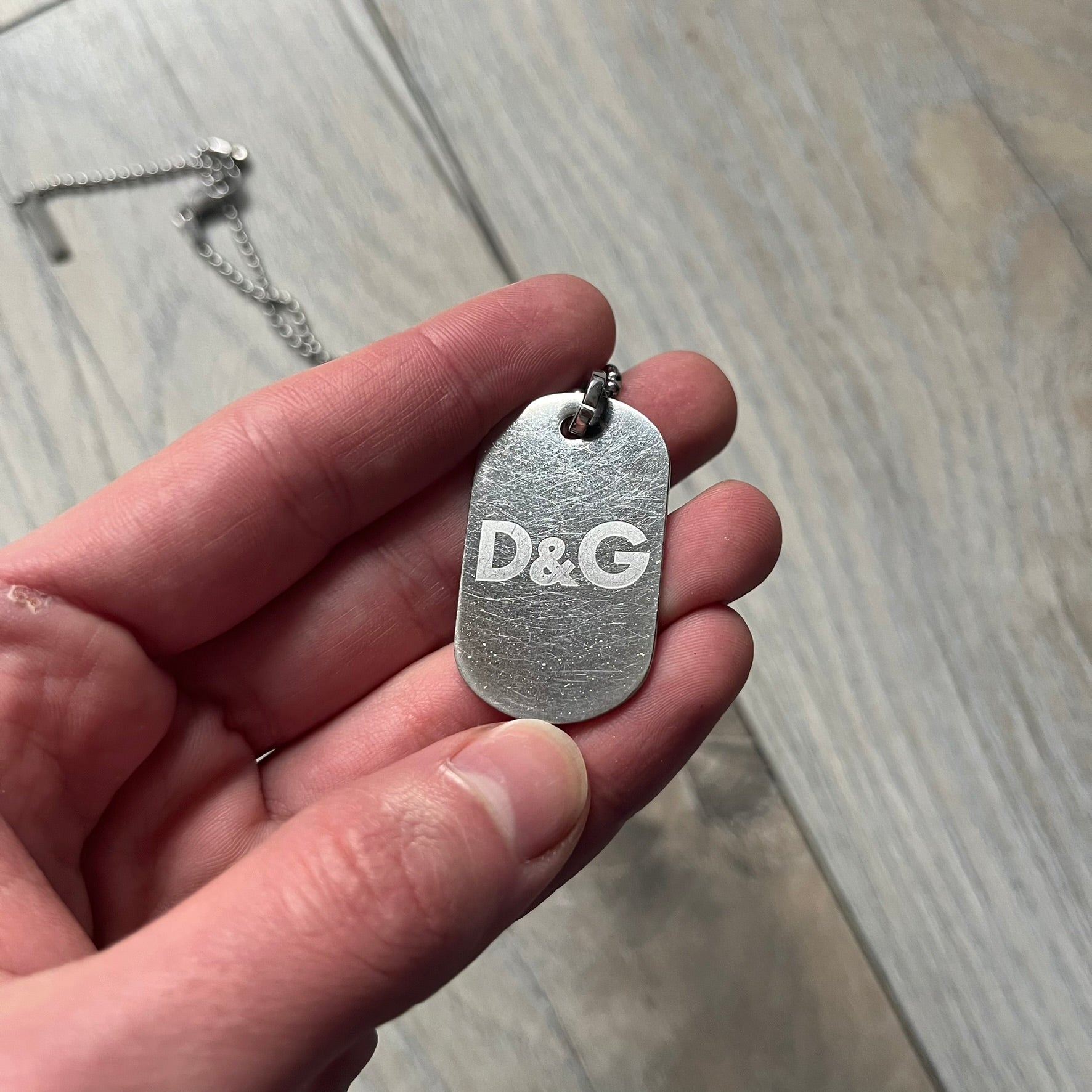 Dolce &amp; Gabbana plain logo dog tag necklace in silver-tone stainless steel, featuring the iconic D&amp;G logo engraved on a sleek tag. Suspended on a classic ball chain with a regulated size. A versatile accessory that combines minimal branding with everyday wearability.