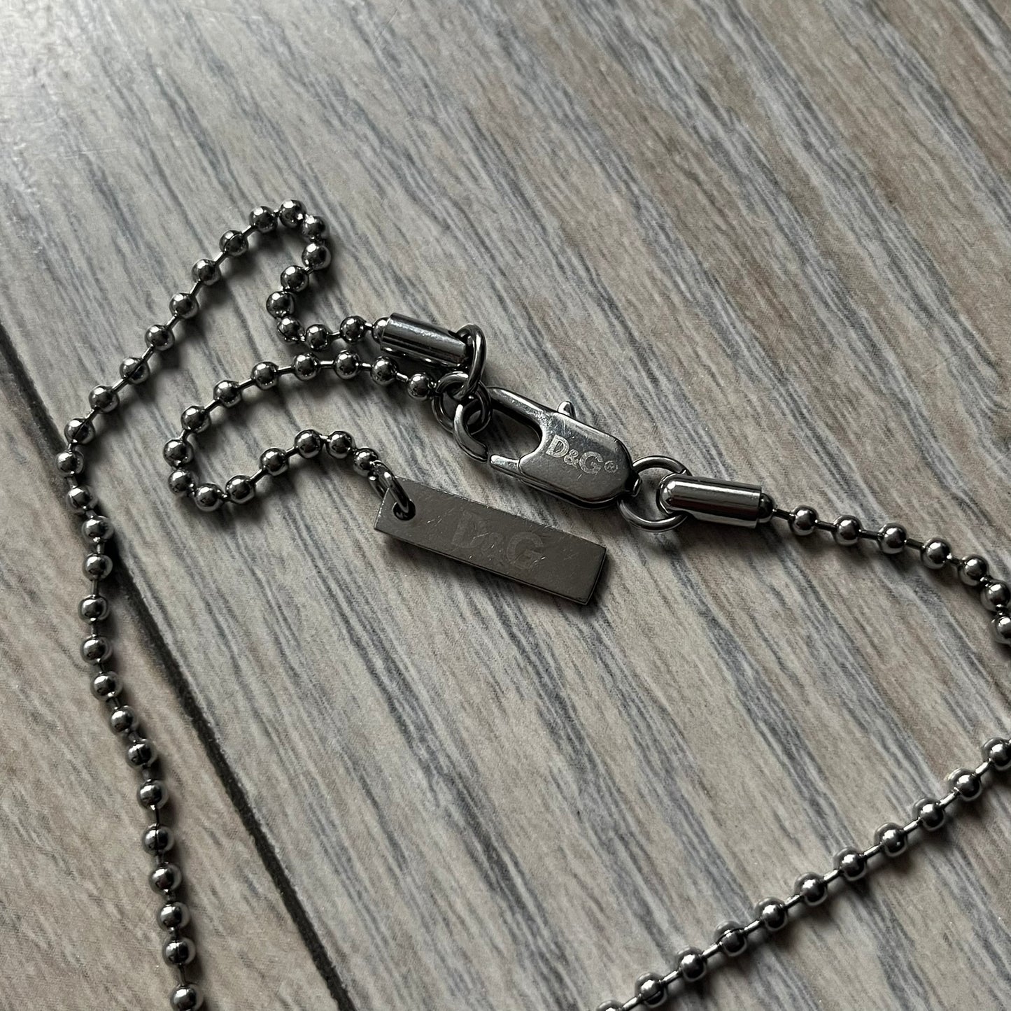 Dolce &amp; Gabbana plain logo dog tag necklace in silver-tone stainless steel, featuring the iconic D&amp;G logo engraved on a sleek tag. Suspended on a classic ball chain with a regulated size. A versatile accessory that combines minimal branding with everyday wearability.