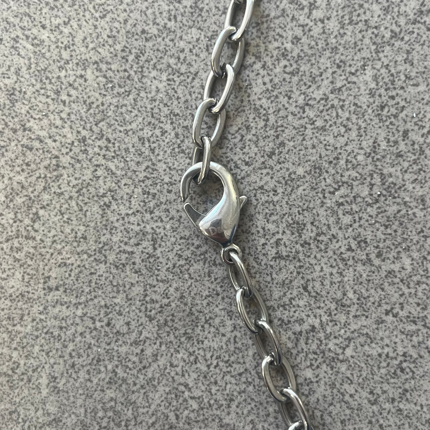 Dolce &amp; Gabbana Propaganda Dog Tag Necklace, featuring a silver stainless steel square tag with four visible screws and the D&amp;G logo engraved on the front. The tag hangs from a durable cable chain, combining sturdy construction with clean, industrial-inspired detailing.