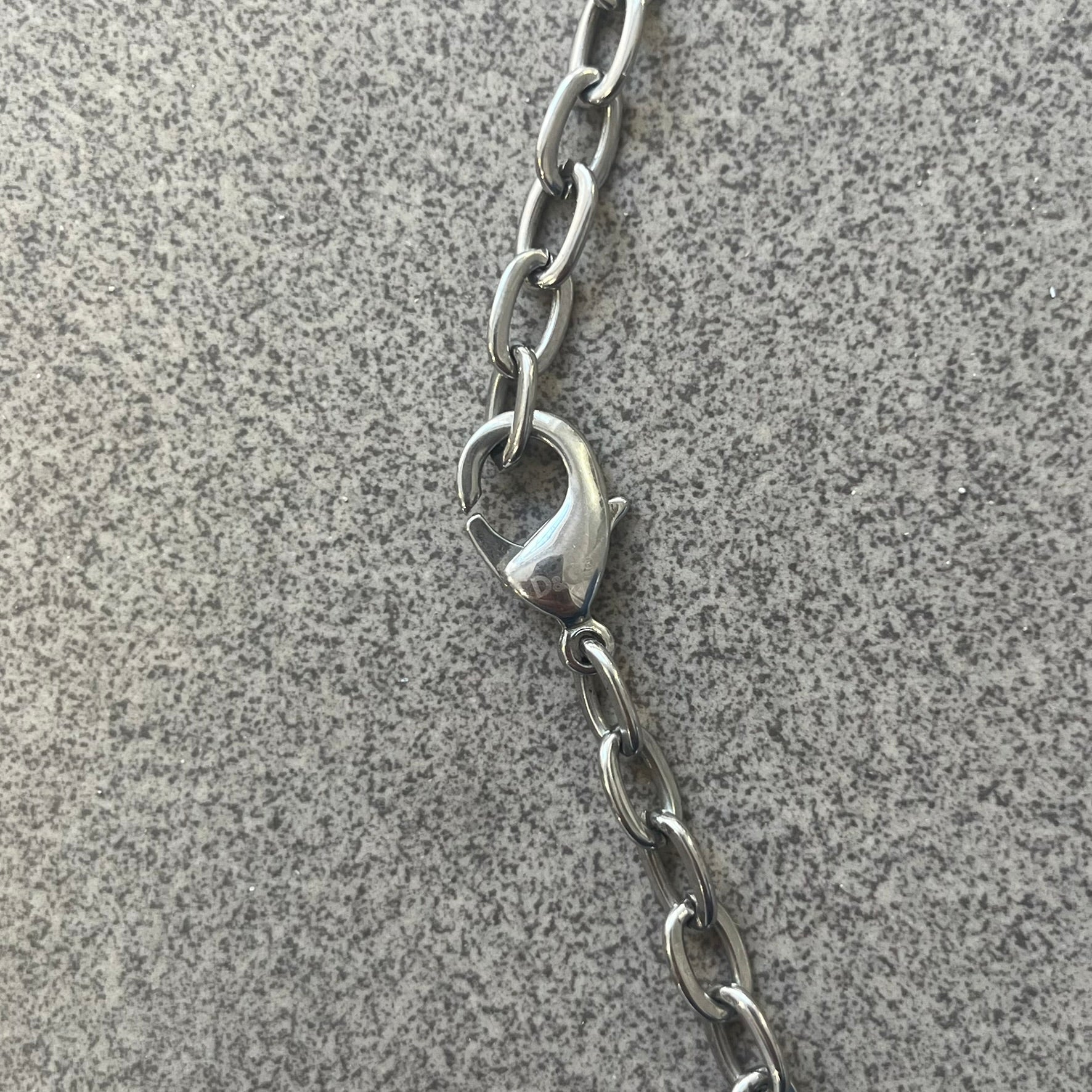 Dolce &amp; Gabbana Propaganda Dog Tag Necklace, featuring a silver stainless steel square tag with four visible screws and the D&amp;G logo engraved on the front. The tag hangs from a durable cable chain, combining sturdy construction with clean, industrial-inspired detailing.