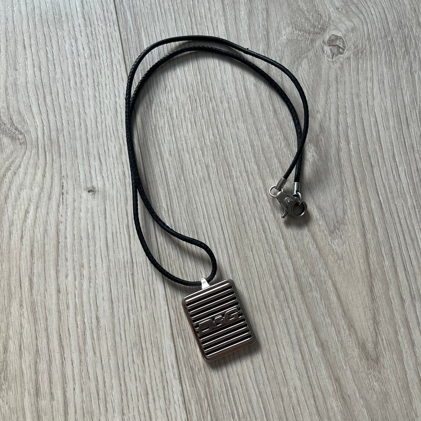 Necklace with a square pendant on a wooden surface