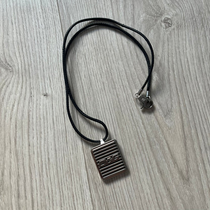 Necklace with a square pendant on a wooden surface