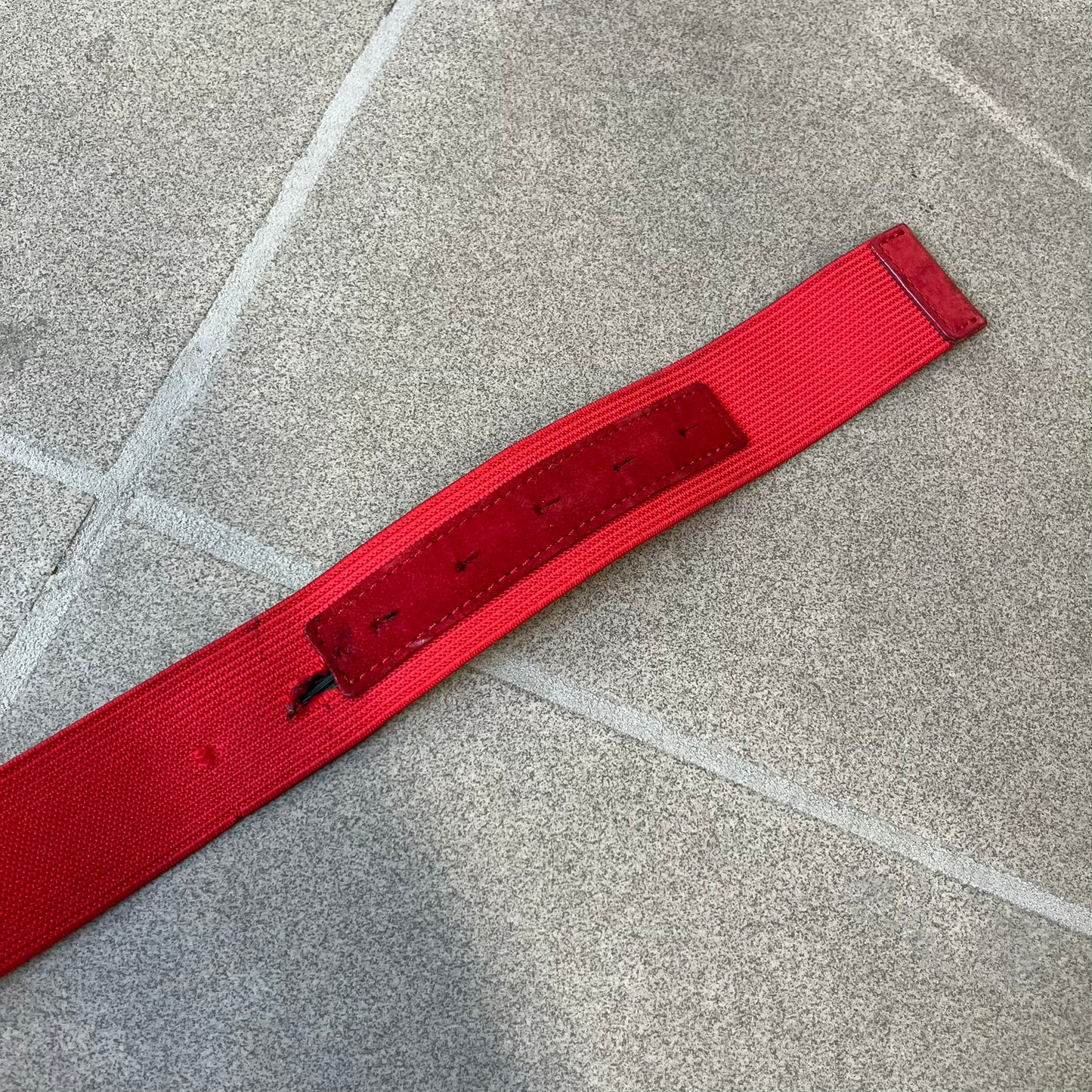 Dolce &amp; Gabbana Red Elastic Hearts Belt is made from red elastic material. The buckle is a metal D&amp;G logo surrounded by eight heart shapes pointing outward, all finished in a dark, aged-looking metal tone. The belt comes with the original hologram tag attached.