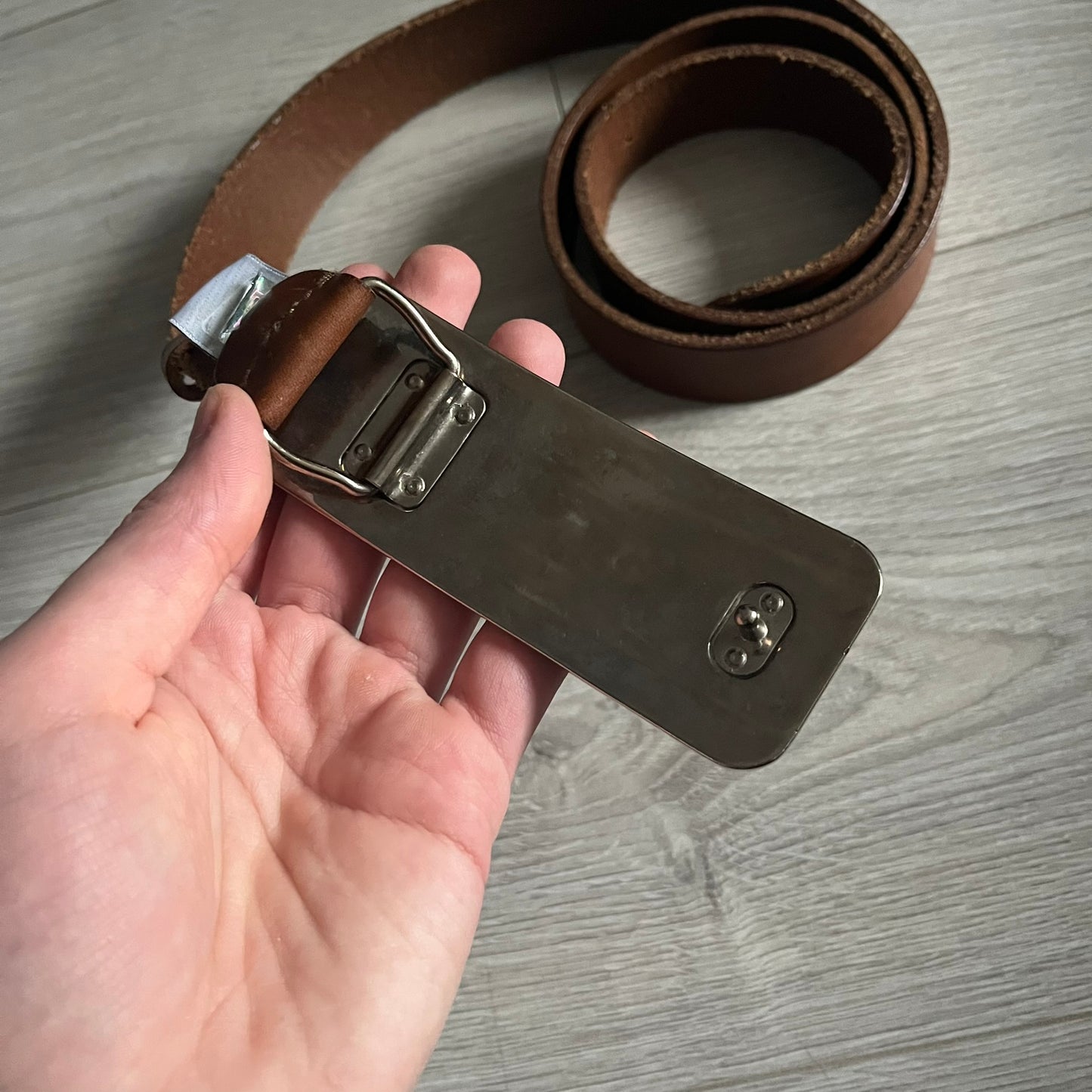 Dolce &amp; Gabbana Red &amp; Blue Leather Belt featuring a rectangular silver-tone buckle with a navy border. The buckle displays a large D&amp;G logo in blue with a red outline and “Dolce &amp; Gabbana” text in blue beneath. Finished with a brown leather strap.
