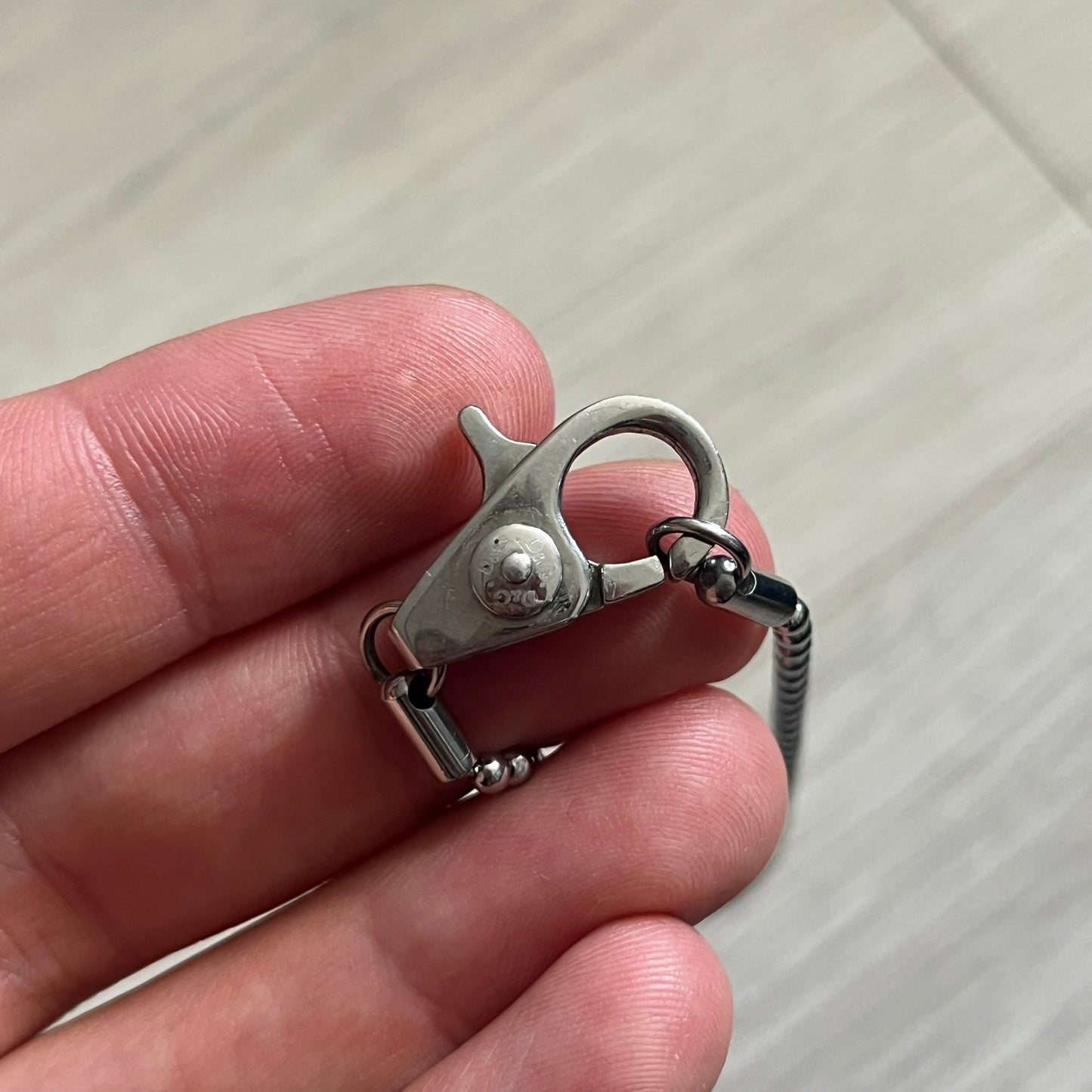 Dolce & Gabbana Rhinestones Dog Tag Necklace DJ0704 crafted from polished stainless steel. Features a rectangular pendant with the iconic D&G logo detailed in rhinestones, and “Dolce & Gabbana” engraved subtly below. Secured with a lobster clasp and finished with a durable ball chain.