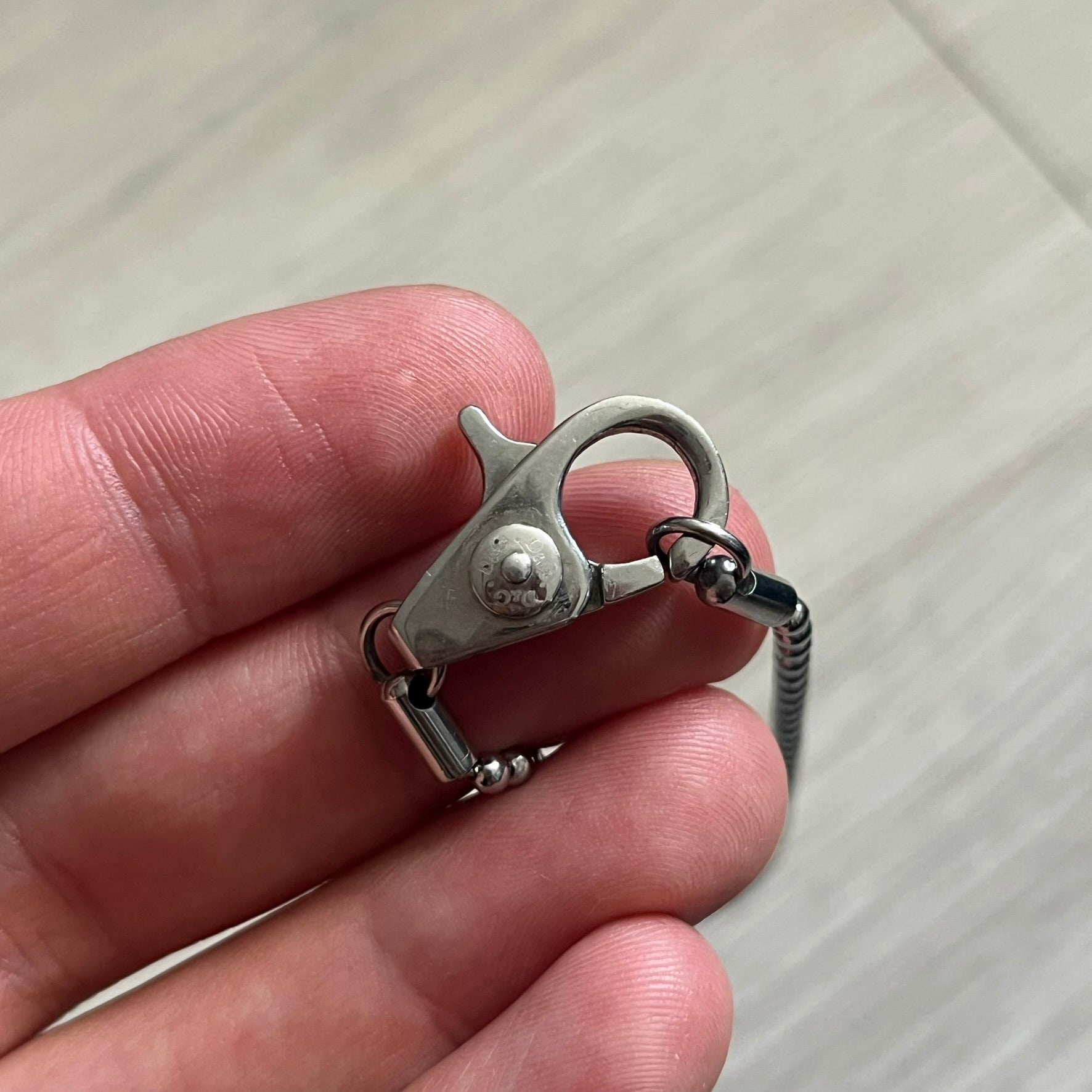 Dolce & Gabbana Rhinestones Dog Tag Necklace DJ0704 crafted from polished stainless steel. Features a rectangular pendant with the iconic D&G logo detailed in rhinestones, and “Dolce & Gabbana” engraved subtly below. Secured with a lobster clasp and finished with a durable ball chain.