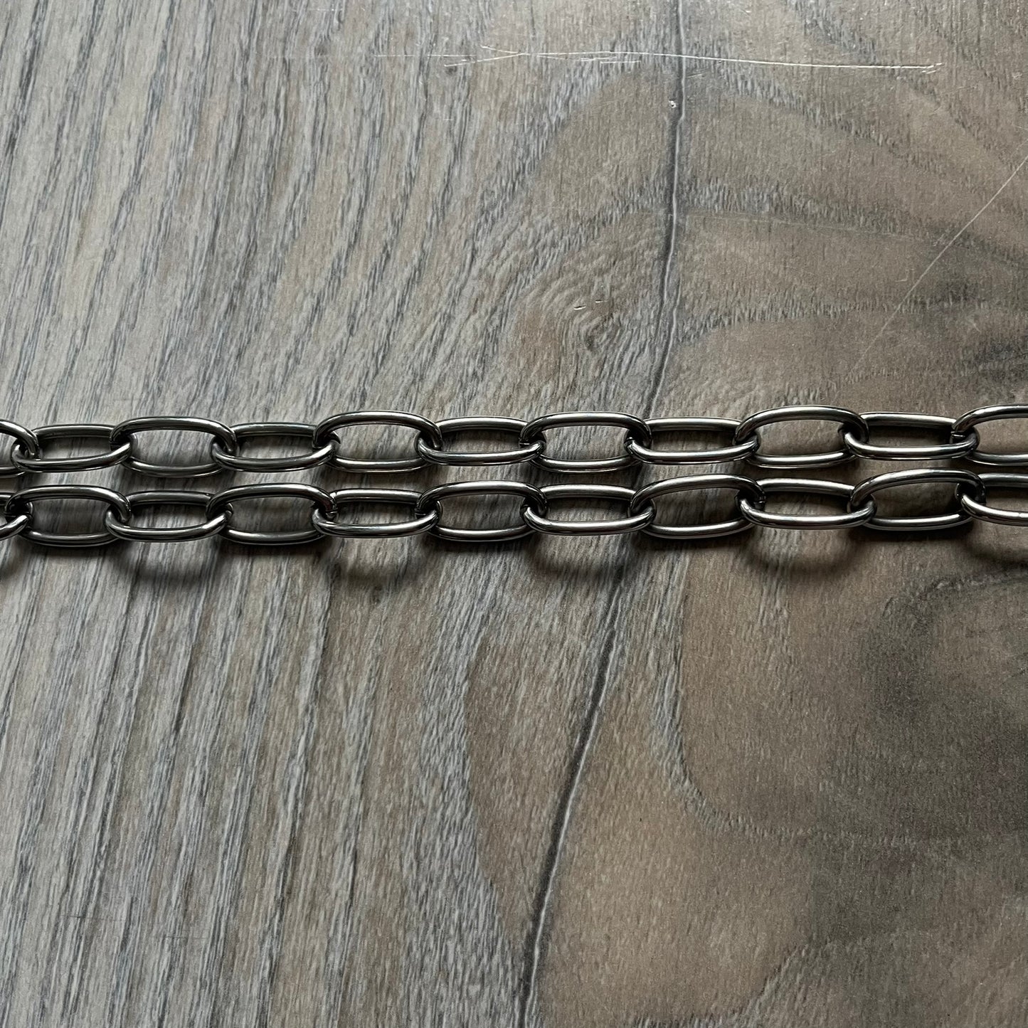 The Dolce &amp; Gabbana Room 13 Carabiner Necklace (DJ0613) is a large, heavy silver-tone necklace featuring a thick paperclip chain with oversized links. At the end of the chain is a large lobster clasp engraved with D&amp;G markings, connected to a branded carabiner. Hanging from the carabiner are two different keys with small D&amp;G logos and a black key identifier with a silver-tone plate engraved with “D&amp;G Dolce &amp; Gabbana Room 13.” The necklace comes with a large silver Dolce &amp; Gabbana dus