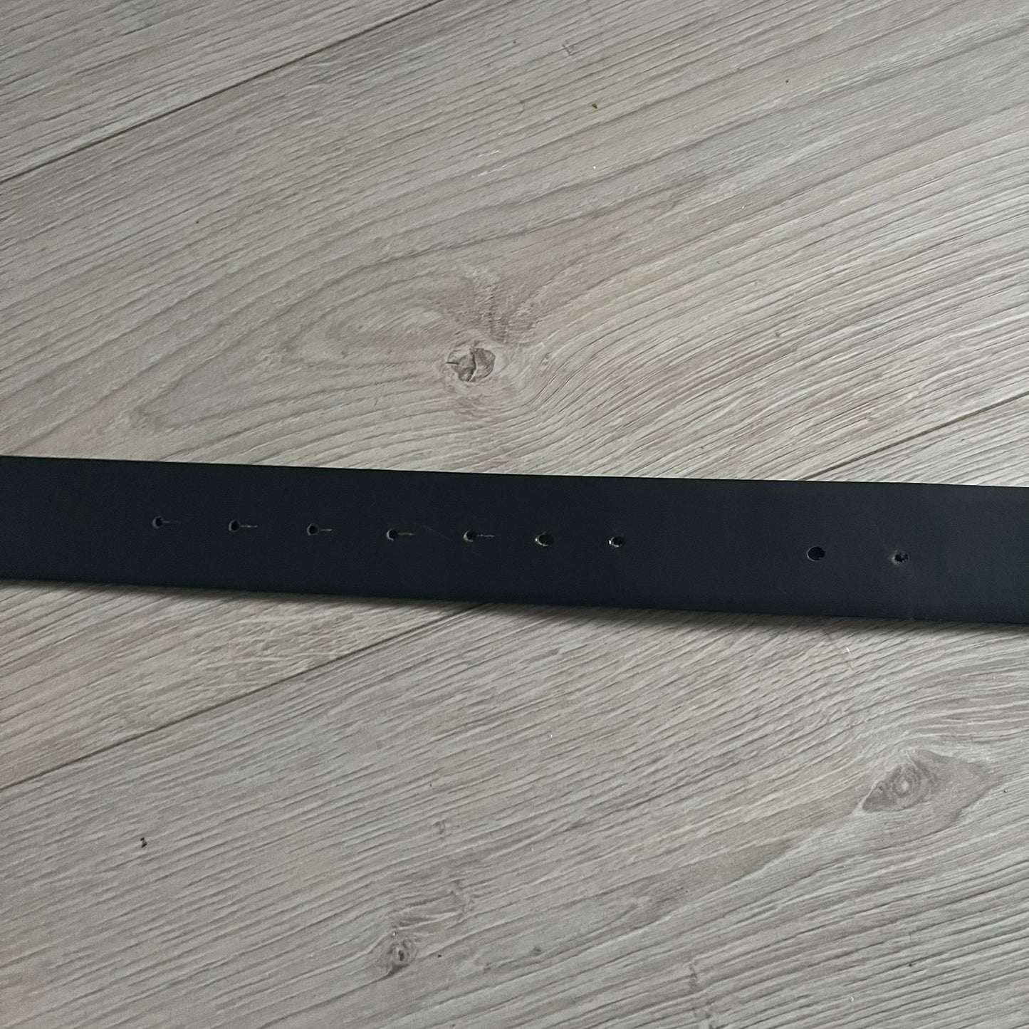 Dolce &amp; Gabbana Round Stamp Belt with a circular, wavy-edged buckle in a metallic finish. The buckle features a beige center with a bold black D&amp;G logo and “Dolce &amp; Gabbana” text beneath. Belt strap is glittery metallic blue with a black inner lining.
