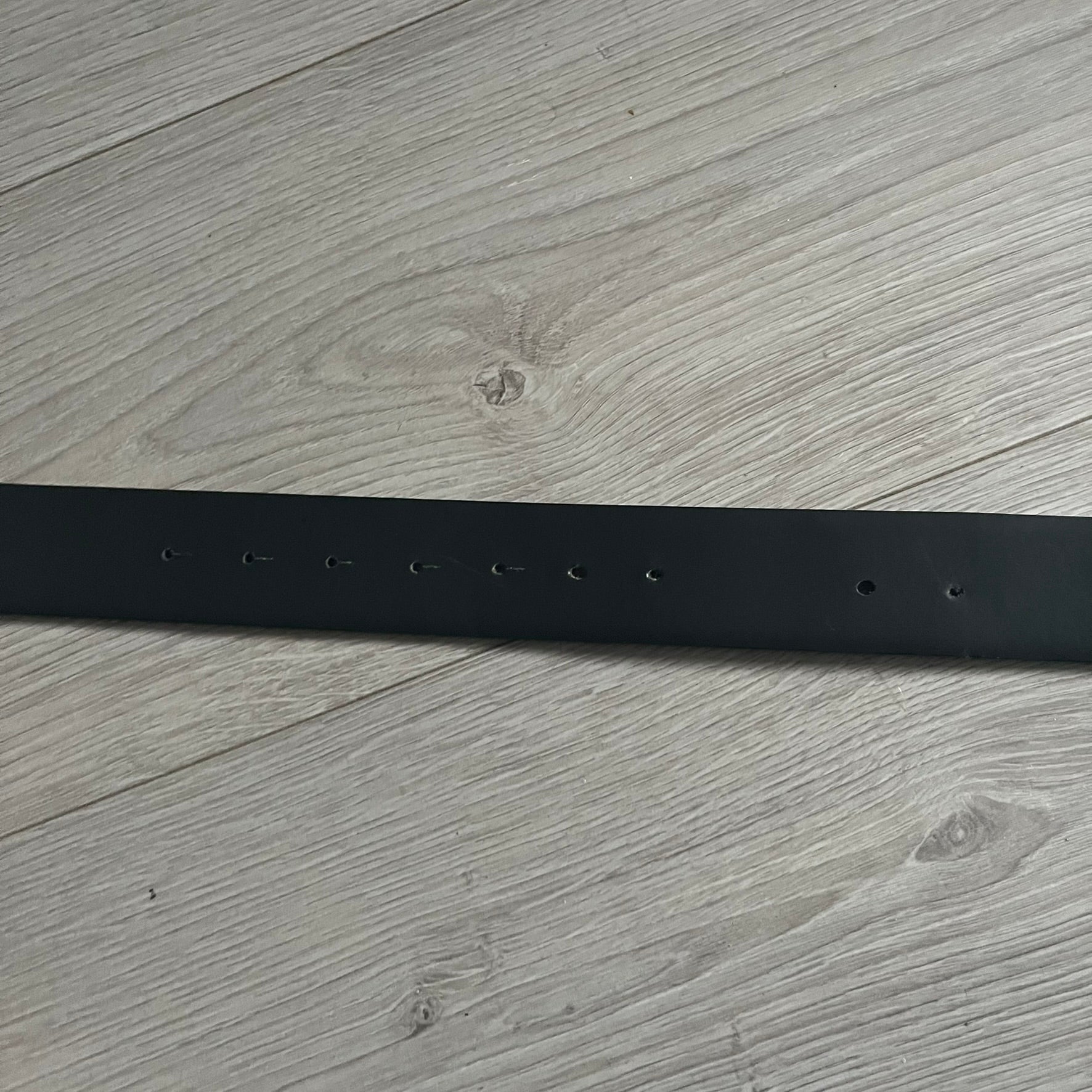 Dolce &amp; Gabbana Round Stamp Belt with a circular, wavy-edged buckle in a metallic finish. The buckle features a beige center with a bold black D&amp;G logo and “Dolce &amp; Gabbana” text beneath. Belt strap is glittery metallic blue with a black inner lining.