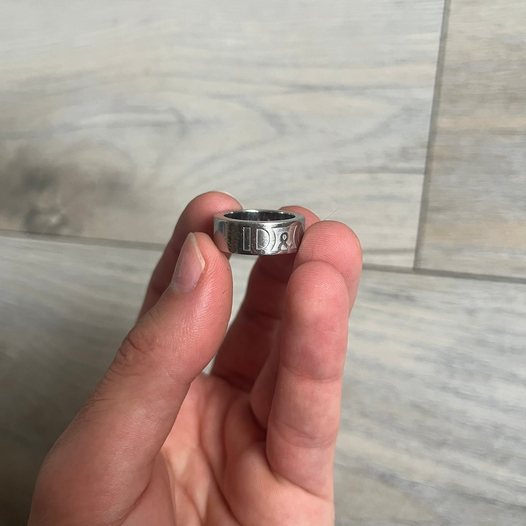Dolce &amp; Gabbana SS04 SEX Ring is a stainless steel ring from the Spring/Summer 2004 collection. The exterior features an engraved D&amp;G logo on one side and “SEX” engraved on the opposite side. The interior is marked with a small D&amp;G logo. It has a thick band construction and polished finish.