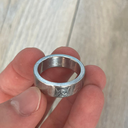 Dolce &amp; Gabbana SS04 SEX Ring is a stainless steel ring from the Spring/Summer 2004 collection. The exterior features an engraved D&amp;G logo on one side and “SEX” engraved on the opposite side. The interior is marked with a small D&amp;G logo. It has a thick band construction and polished finish.