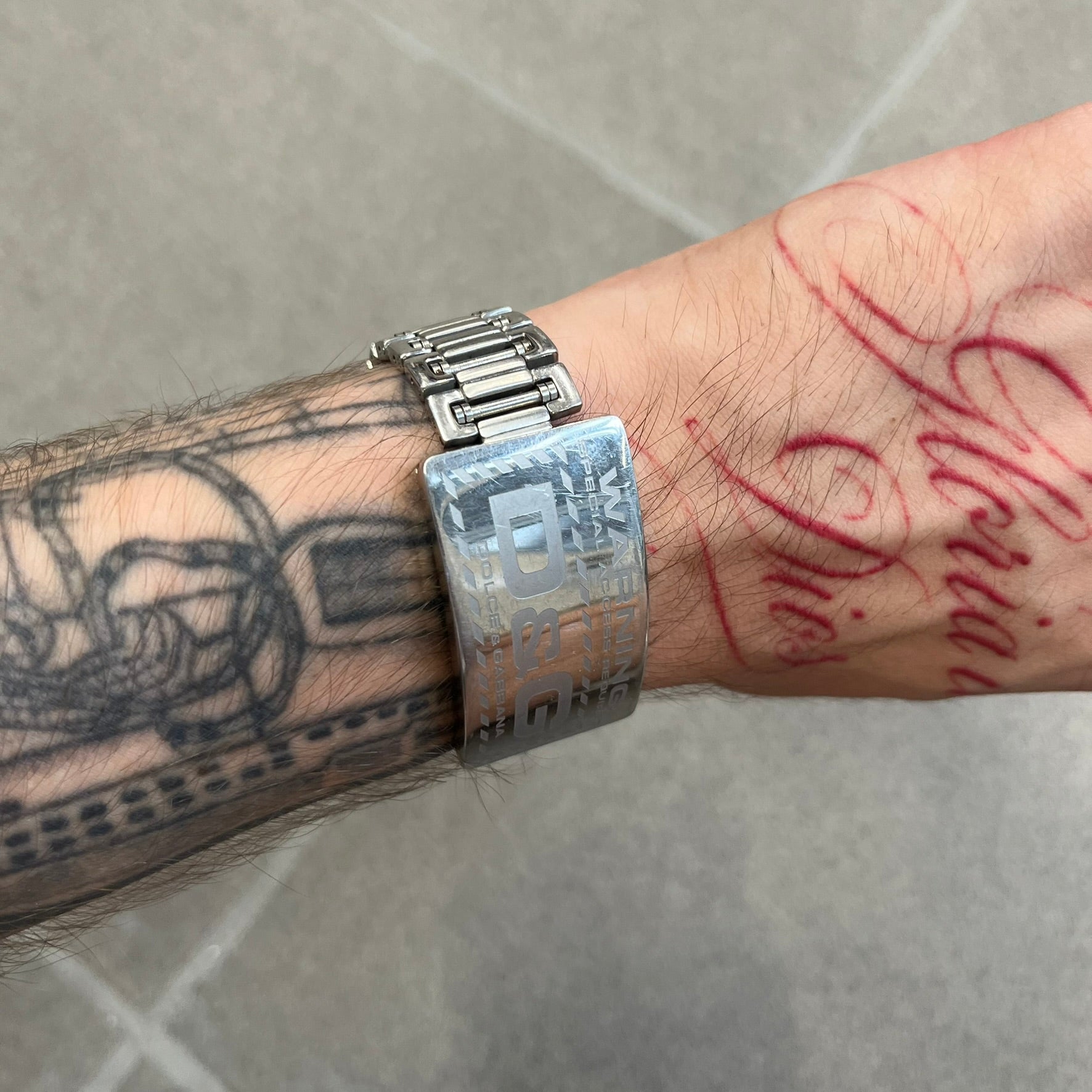 Dolce &amp; Gabbana Warning Stainless Steel Bracelet. From the Spring/Summer 2006 collection, this bracelet features a polished stainless steel design with a clip closure. The front plate displays “Warning Special Access Required” alongside D&amp;G Dolce &amp; Gabbana branding.