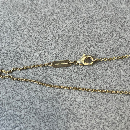 Dolce &amp; Gabbana SS25 Gold Cross Necklace features a gold-tone brass chain with a detailed 3D cross pendant depicting Jesus. A Dolce &amp; Gabbana plaque with “Made in Italy” text is positioned near the clasp. Comes with the original black box and certificate card.