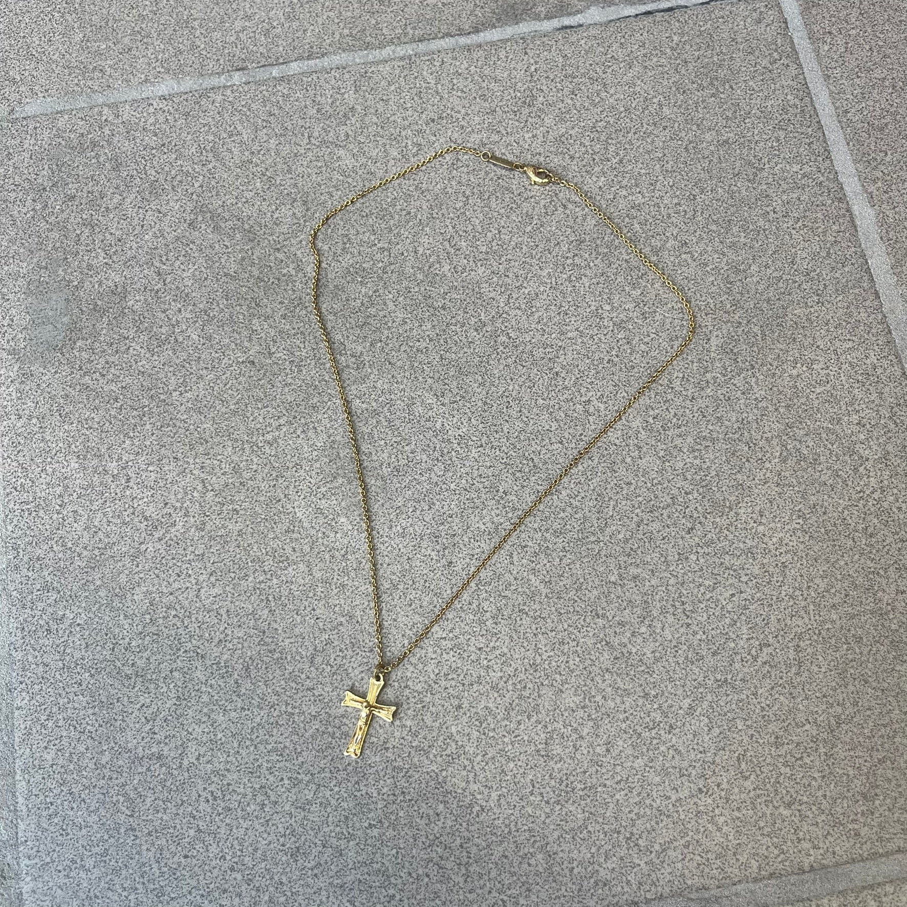 Dolce &amp; Gabbana SS25 Gold Cross Necklace features a gold-tone brass chain with a detailed 3D cross pendant depicting Jesus. A Dolce &amp; Gabbana plaque with “Made in Italy” text is positioned near the clasp. Comes with the original black box and certificate card.