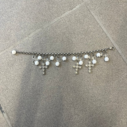 Dolce &amp; Gabbana Silver Charm Cross DJ0253 Bracelet features a silver-tone chain bracelet with white bead charms, three cross-shaped charms made from circular elements, and a D&amp;G logo charm. The bracelet has a silver-tone metal construction.&nbsp;