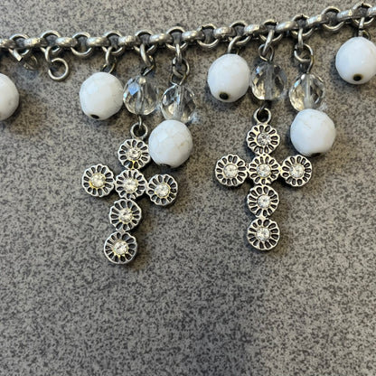 Dolce &amp; Gabbana Silver Charm Cross DJ0253 Bracelet features a silver-tone chain bracelet with white bead charms, three cross-shaped charms made from circular elements, and a D&amp;G logo charm. The bracelet has a silver-tone metal construction.&nbsp;