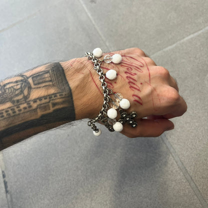 Dolce &amp; Gabbana Silver Charm Cross DJ0253 Bracelet features a silver-tone chain bracelet with white bead charms, three cross-shaped charms made from circular elements, and a D&amp;G logo charm. The bracelet has a silver-tone metal construction.&nbsp;