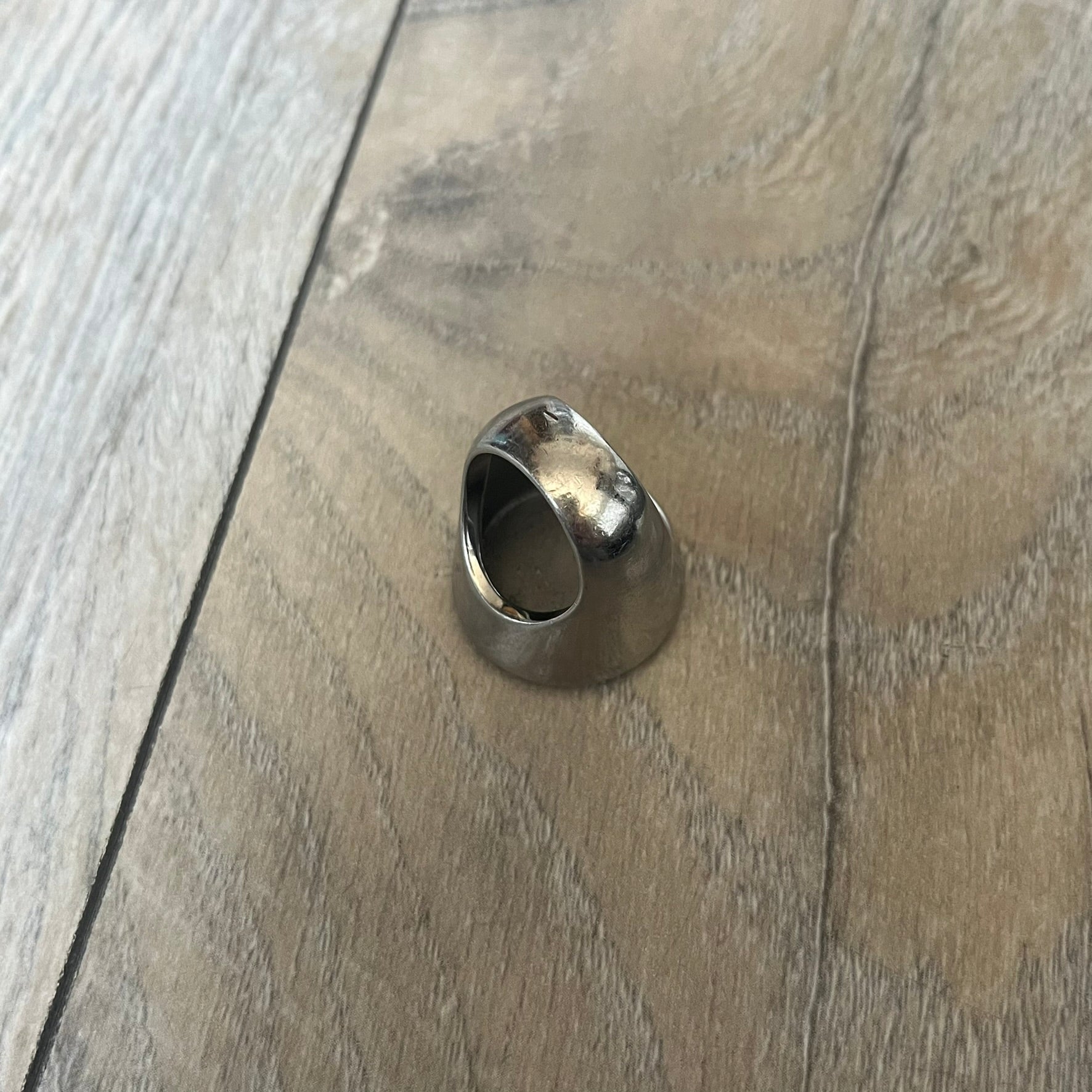 The Dolce &amp; Gabbana Silver Logo Signet Ring is a silver-tone metal signet ring with a thick, substantial design. The top features a beige background with the D&amp;G logo in silver tone, outlined in silver. The signet is large and solid.
