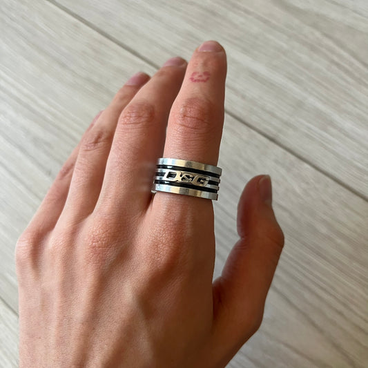 Dolce &amp; Gabbana stainless steel ring DJ0709 in silver, featuring three subtle black engraved stripes encircling the band. The D&amp;G logo is displayed in polished silver on top, creating a nice contrast with the dark detailing.