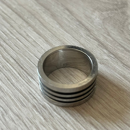Dolce &amp; Gabbana stainless steel ring DJ0709 in silver, featuring three subtle black engraved stripes encircling the band. The D&G logo is displayed in polished silver on top, creating a nice contrast with the dark detailing.