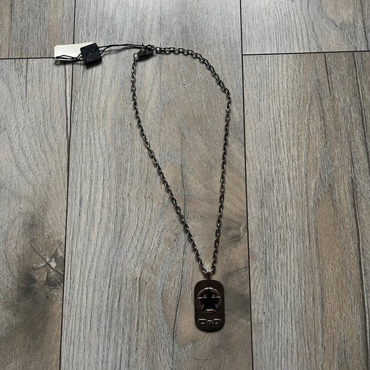 The Dolce & Gabbana Star Dog Tag Necklace (DJ0889) is a heavy stainless steel necklace featuring a thick, oversized dog tag pendant. The front of the pendant has a raised black star mounted on a silver-tone circular base, with open cutout sections between the star and the circle. A raised D&G logo is positioned at the lower front of the dog tag. The necklace is finished with a lobster clasp and has a solid, weighty construction throughout.