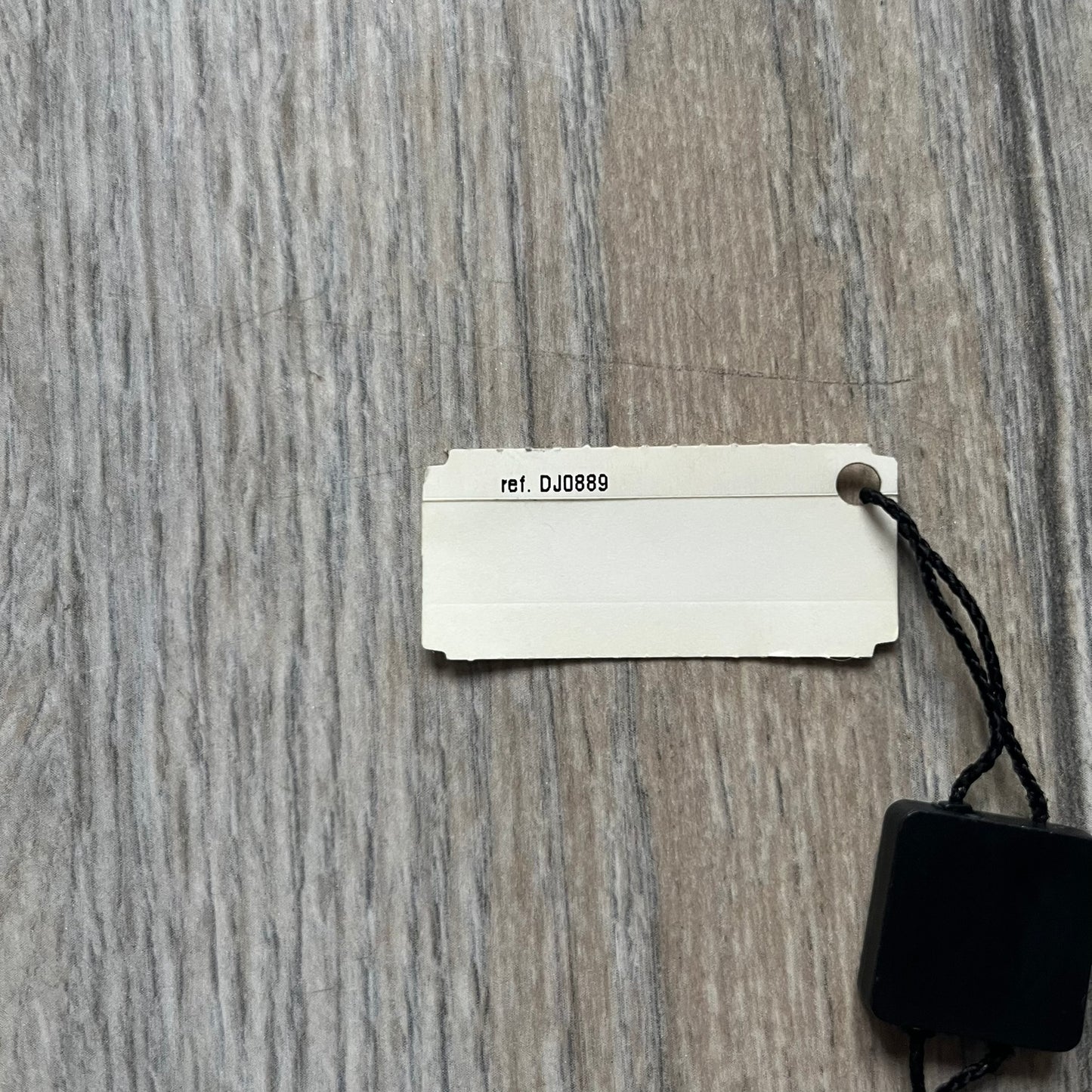 The Dolce & Gabbana Star Dog Tag Necklace (DJ0889) is a heavy stainless steel necklace featuring a thick, oversized dog tag pendant. The front of the pendant has a raised black star mounted on a silver-tone circular base, with open cutout sections between the star and the circle. A raised D&G logo is positioned at the lower front of the dog tag. The necklace is finished with a lobster clasp and has a solid, weighty construction throughout.