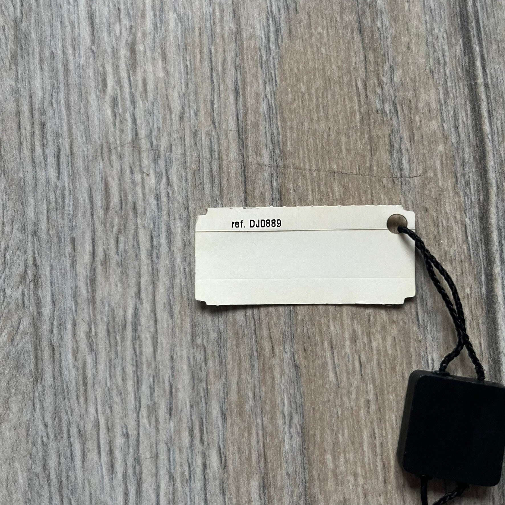 The Dolce & Gabbana Star Dog Tag Necklace (DJ0889) is a heavy stainless steel necklace featuring a thick, oversized dog tag pendant. The front of the pendant has a raised black star mounted on a silver-tone circular base, with open cutout sections between the star and the circle. A raised D&G logo is positioned at the lower front of the dog tag. The necklace is finished with a lobster clasp and has a solid, weighty construction throughout.