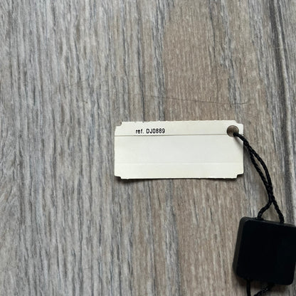 The Dolce & Gabbana Star Dog Tag Necklace (DJ0889) is a heavy stainless steel necklace featuring a thick, oversized dog tag pendant. The front of the pendant has a raised black star mounted on a silver-tone circular base, with open cutout sections between the star and the circle. A raised D&G logo is positioned at the lower front of the dog tag. The necklace is finished with a lobster clasp and has a solid, weighty construction throughout.