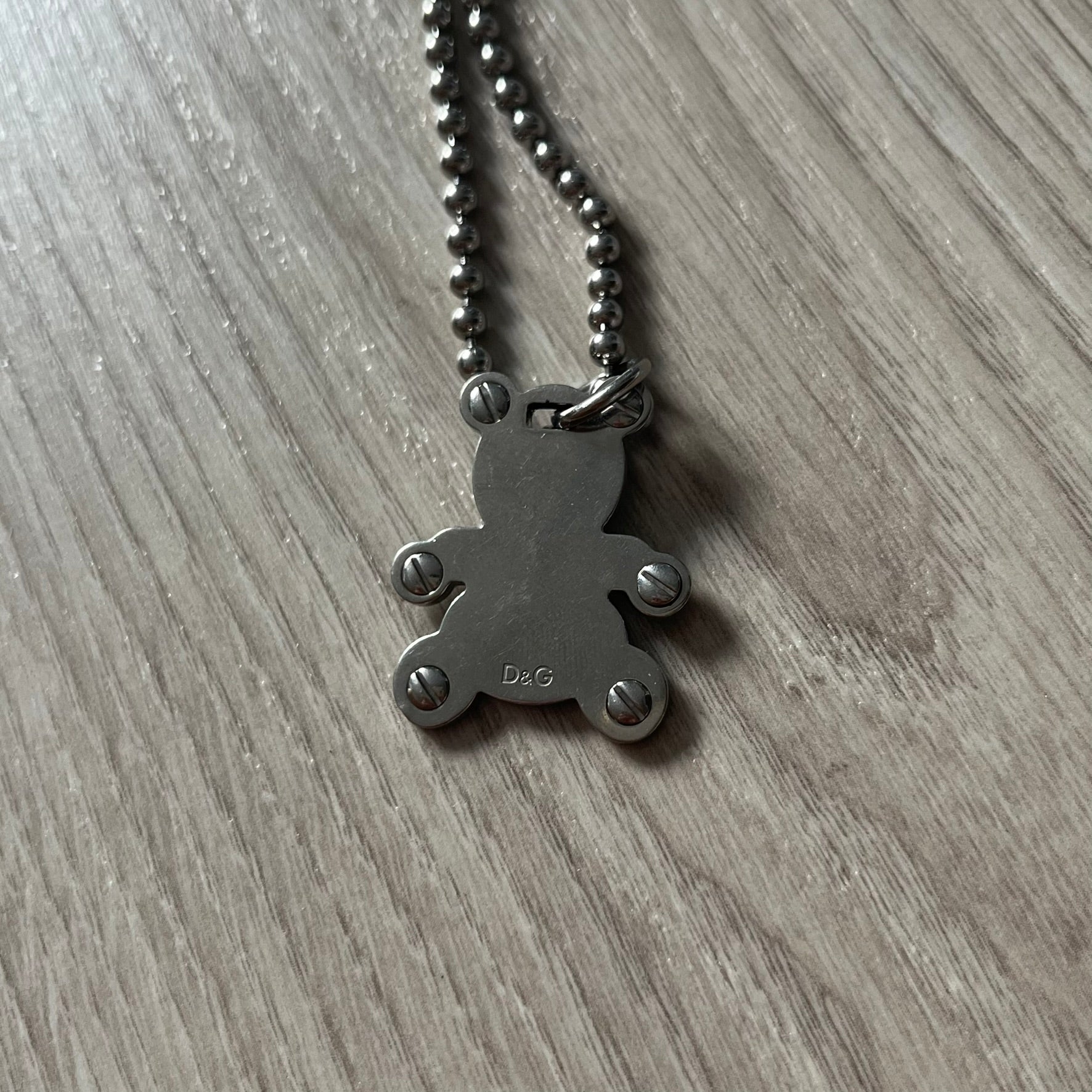 Metallic pendant necklace on a wooden surface