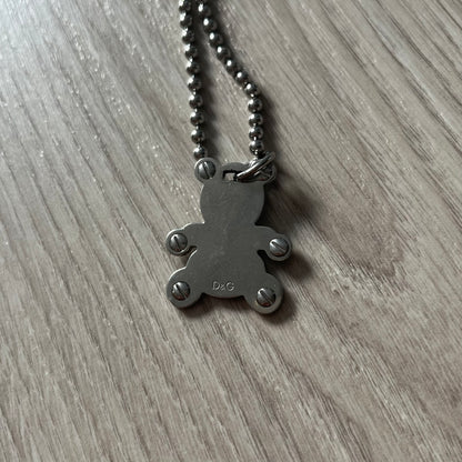 Metallic pendant necklace on a wooden surface
