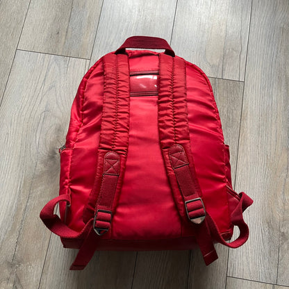 The Dolce & Gabbana "We Are D&G" Red Backpack is crafted from durable red nylon with metal hardware and features a graffiti-inspired "We Are D&G" logo embroidered on the front. It has a top zip closure, exterior zip pocket, padded back panel, and adjustable shoulder straps with canvas and faux leather details. The backpack also includes a top handle, rear identification label holder, and is made in Italy.