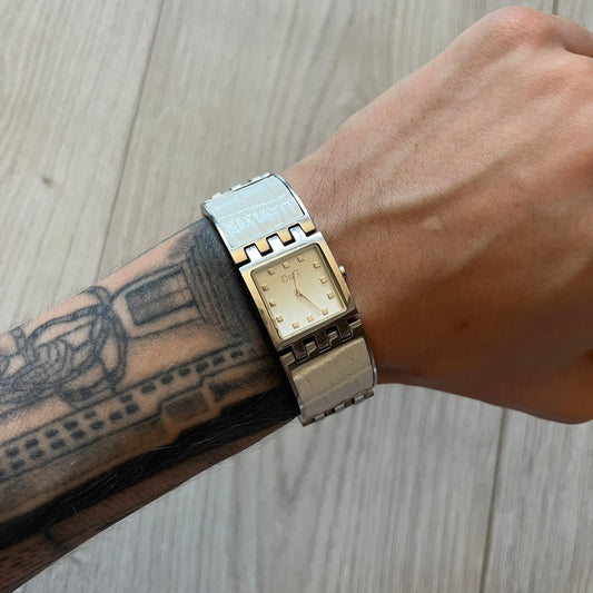 Dolce &amp; Gabbana white analog watch with a silver bracelet featuring white leather-like panels. The case seamlessly aligns with the width of the bracelet for a sleek, integrated look. A refined statement piece blending luxury design with modern elegance.